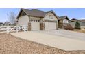 A well-maintained home with a large driveway and a three-car garage, complemented by a white fence at 10882 E 162Nd Pl, Brighton, CO 80602