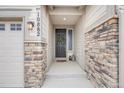 Inviting front entrance with stone accents, a dark-colored door, and stylish outdoor decor at 10882 E 162Nd Pl, Brighton, CO 80602