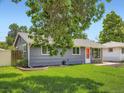 Charming single-story home with a lush green lawn, well-maintained landscaping, and vibrant orange front door at 3750 S Galapago St, Englewood, CO 80110