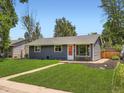 Delightful single-story home featuring a well-kept lawn and a striking orange front door at 3750 S Galapago St, Englewood, CO 80110