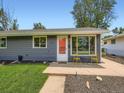 Inviting single-story house with vibrant orange door and cute yellow bistro set on the front stoop at 3750 S Galapago St, Englewood, CO 80110