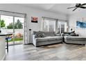Cozy living room with sliding glass doors to the backyard and gray couches at 5131 Andes St, Denver, CO 80249