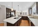 Spacious kitchen featuring an island with cooktop, stainless steel appliances, and tile backsplash at 11010 Grayledge Cir, Highlands Ranch, CO 80130