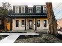 Charming two-story home with a black metal roof, covered porch, and landscaped front yard at 1016 28Th St, Denver, CO 80205