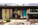 Stunning front entry featuring an eye-catching turquoise door and artistic landscaping at 3605 W Berry Ave, Littleton, CO 80123