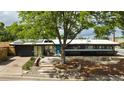 Inviting single-story home with xeriscaping, stone pathway, and a beautiful, mature shade tree at 3605 W Berry Ave, Littleton, CO 80123