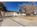 Attractive single-story home featuring a spacious driveway leading to a two-car garage and a well-maintained front lawn at 6699 S Pennsylvania St, Centennial, CO 80121