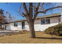 Classic white brick home with a neatly landscaped lawn, providing excellent curb appeal in a quiet neighborhood at 6699 S Pennsylvania St, Centennial, CO 80121