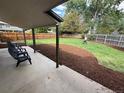 Spacious backyard with a covered patio and newly landscaped area with fresh mulch and green grass at 1420 S Leyden St, Denver, CO 80224