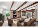 Bright living room with exposed wood beams, brick fireplace, and sliding doors to the patio at 420 Dudley St, Lakewood, CO 80226