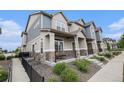 Side angle of a charming townhouse featuring a covered porch and manicured landscaping at 20000 E 40Th Ave # 4, Denver, CO 80249