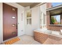 Inviting front porch with a stylish brown door, brick accents, and a 'HOME' welcome mat at 4535 W 50Th Ave, Denver, CO 80212