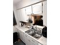 Close-up of the kitchen sink, countertop, and cabinets with modern fixtures and ample space at 3626 S Granby Way # L03, Aurora, CO 80014