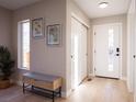 Bright entryway featuring a stylish bench, modern light fixture, and closet for convenient storage at 4341 N Columbine St, Denver, CO 80216