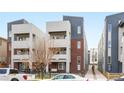 Modern townhouse with brick and gray siding featuring a small yard with black metal fence at 1733 Irving St # 101, Denver, CO 80204