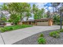 Wide driveway leading to a brick home with a two-car garage, basketball hoop and landscaped yard at 5890 W Quarles Dr, Littleton, CO 80128
