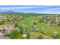 Expansive aerial view showcasing the lush green landscape, mountains, and surrounding neighborhood at 10389 W Fair Ave # E, Littleton, CO 80127