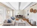 Bright living room featuring modern decor, exposed beams and seamless flow to the dining area at 9725 E Harvard Ave # 434, Denver, CO 80231