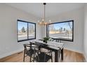 Bright dining room with a modern chandelier, a black table and large windows offering neighborhood views at 4101 S Lincoln St, Englewood, CO 80113