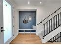 Inviting entryway with a built-in bench, coat hooks, and stylish decor adjacent to a staircase at 4101 S Lincoln St, Englewood, CO 80113