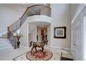 Grand two-story foyer with winding staircase and elegant tile flooring, showcasing a decorative horse statue at 15857 E Aberdeen Ave, Centennial, CO 80016