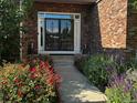 Brick home featuring a walkway leading to a front door with black trim and decorative flower beds at 15857 E Aberdeen Ave, Centennial, CO 80016