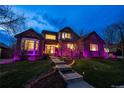 Charming two-story home featuring landscaped front yard with mature trees and illuminated by inviting purple lights at 15857 E Aberdeen Ave, Centennial, CO 80016