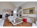Bright living room featuring hardwood floors, a decorative mirror, and an archway to the dining area at 15857 E Aberdeen Ave, Centennial, CO 80016