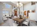 Spacious living room and dining area with large windows and wooden door at 12518 W 77Th Pl, Arvada, CO 80005