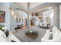 Bright open-concept living room and dining area with soaring ceilings at 12518 W 77Th Pl, Arvada, CO 80005