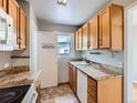 A kitchen featuring light wood cabinetry, granite countertops, and modern appliances at 1856 S Steele St, Denver, CO 80210