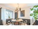 Dining room with modern light fixture, round table with black chairs, and large window at 1470 S Quebec Way # 8, Denver, CO 80231