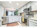 Bright kitchen featuring stainless steel appliances, white subway tile backsplash and a colorful rug at 1470 S Quebec Way # 8, Denver, CO 80231