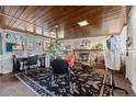 Cozy living room with wood ceiling, fireplace, sewing machines, and comfortable seating at 7400 W Quincy Ave, Littleton, CO 80123