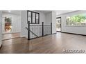 Bright foyer with hardwood floors, black iron stair railings, and a view to the front door at 4585 S Elati St, Englewood, CO 80110