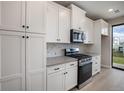 Well-equipped kitchen featuring stainless steel appliances and sleek white cabinetry at 2078 S Holly St # 2, Denver, CO 80222