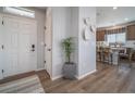 Bright foyer with wood flooring, a white door, and a decorative plant, leading into the home's living space at 21927 E 51St Dr, Aurora, CO 80019