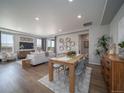 Open-concept living space with dining area, modern decor, hardwood floors, and abundant natural light at 21927 E 51St Dr, Aurora, CO 80019