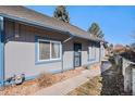 Exterior view of a gray condominium with blue trim, surrounded by well-maintained grounds at 2490 S Worchester Ct # E, Aurora, CO 80014