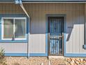 Close up of gray home with blue trim, an ornamental metal security door, and front door address at 2490 S Worchester Ct # E, Aurora, CO 80014