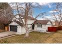 Charming two-story home featuring a black garage door and painted white brick at 6426 Zang Ct, Arvada, CO 80004