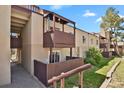 Exterior shot features a private patio with wood railing and stairway, offering an inviting outdoor space at 9725 E Harvard Ave # 305, Denver, CO 80231