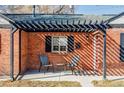 Cozy front porch with a pergola, seating area, and charming brick details, perfect for relaxing outdoors at 3641 N Cook St, Denver, CO 80205