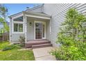 Welcoming front entrance with a covered porch, light gray facade, and well-maintained landscaping at 744 Owl Dr, Louisville, CO 80027