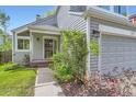 Beautifully landscaped front entrance featuring a light gray facade and arched front door at 744 Owl Dr, Louisville, CO 80027