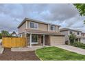 Tan two-story home featuring stone accents, well-kept lawn, and a two car garage at 3853 Orleans Ct, Denver, CO 80249