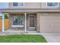 Front exterior of home showcasing tan siding, stonework, and a two-car garage at 3853 Orleans Ct, Denver, CO 80249