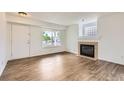 Bright living room with hardwood floors, fireplace, and large window at 3853 Orleans Ct, Denver, CO 80249