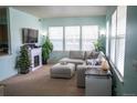 Bright living room with large windows, fireplace and comfortable seating at 7472 E 28Th Ave, Denver, CO 80238