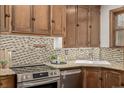 Kitchen featuring stainless steel appliances, granite countertops, and wooden cabinets with a tile backsplash at 1138 E 14Th Ave # 12, Denver, CO 80218